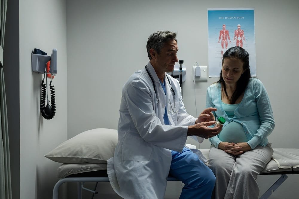 médico conversando com paciente grávida