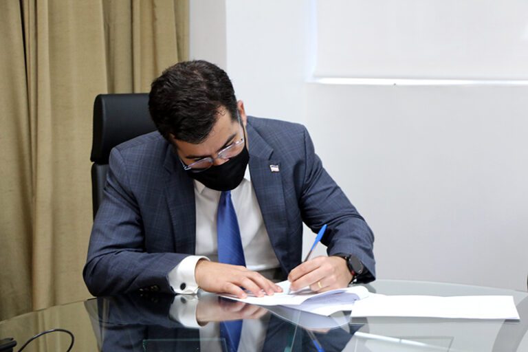 O Procurador-Geral do Estado, Jasson Amaral Hibner, assinando um documento.