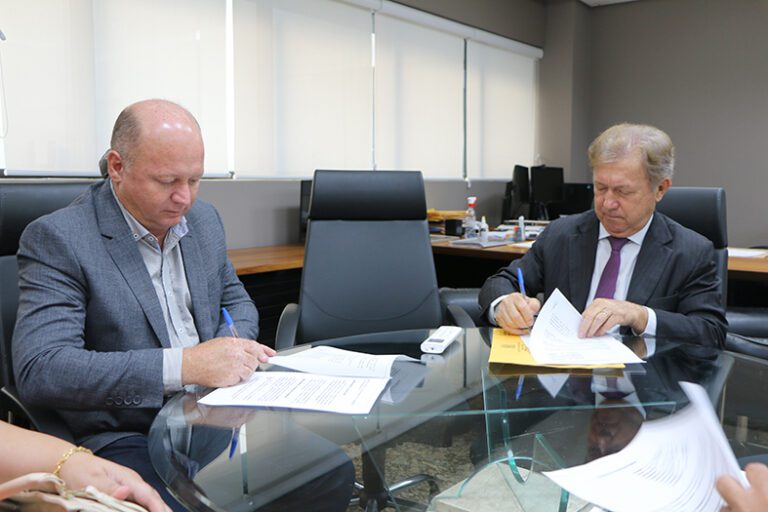 O presidente do TJES, desembargador fabio Clem de Oliveira, e o prefeito de Mantenópolis/ES assinam um documento.